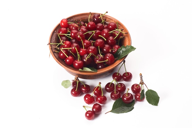 Bowl of fresh red cherries on white background