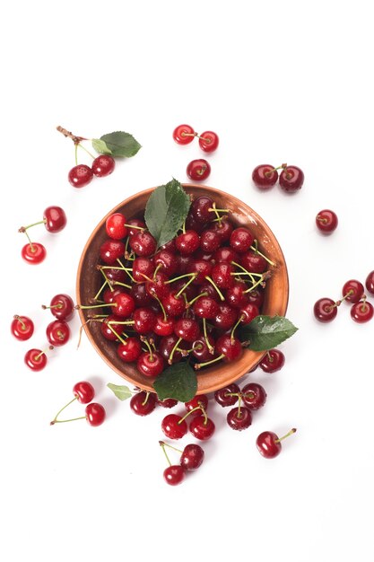 Bowl of fresh red cherries on white background