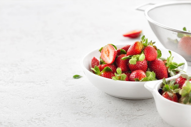 Bowl of fresh strawberries on white background