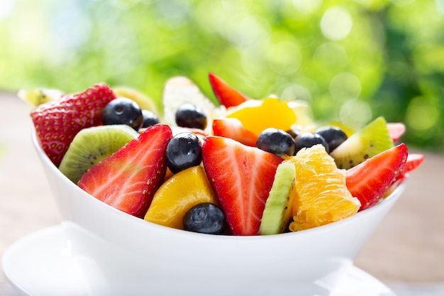 Bowl of fruit salad on a green background