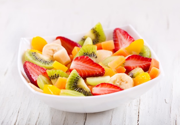 Bowl of fruit salad on a wooden table