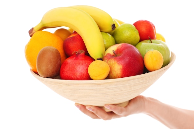 a bowl of fruits over white background