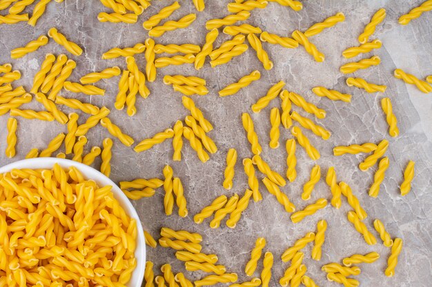 A bowl of gemelli pasta, on the marble.