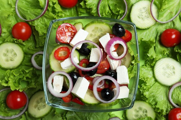 Bowl of greek salad and ingredients, top view