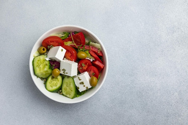 A bowl of greek salad with feta cheese and feta cheese