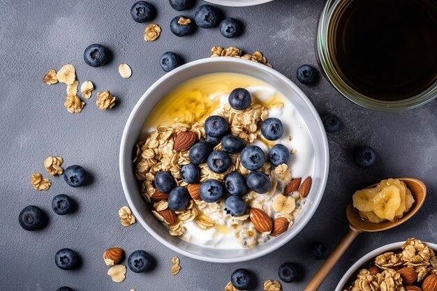 Bowl of greek yogurt with oatmeal granola banana blueberry nuts chia seeds and honey on gray table Top view generate ai