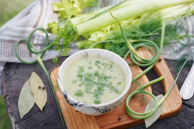 Чаша зеленого крем-супа на деревянном столе