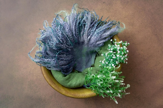 A bowl of green and purple flowers sits on a table.