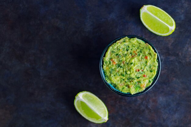 Photo bowl of guacamole on a dark background. traditional mexican dip sauce guacamole. traditional mexican food. copy space. top view