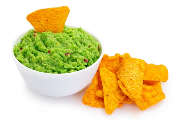 Photo bowl of guacamole with nachos isolated on white background