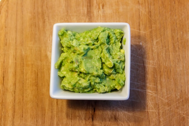 Bowl of guacamole on a wooden table