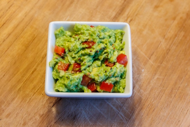 Bowl of guacamole on a wooden table