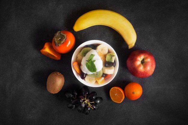 Bowl of healthy fresh fruit salad on black chalkboard