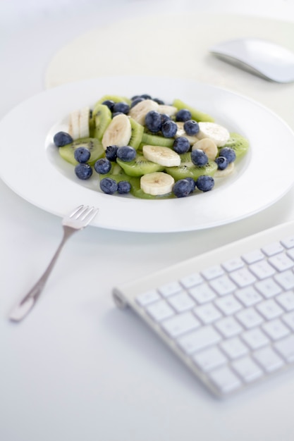 Photo bowl of healthy fresh fruit salad on white background