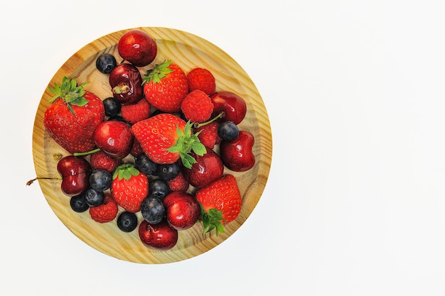 Bowl of healthy fresh fruit on white background, top view