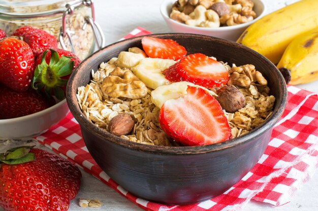 Ciotola di muesli di frutta fatti in casa con fragole, banana e noci