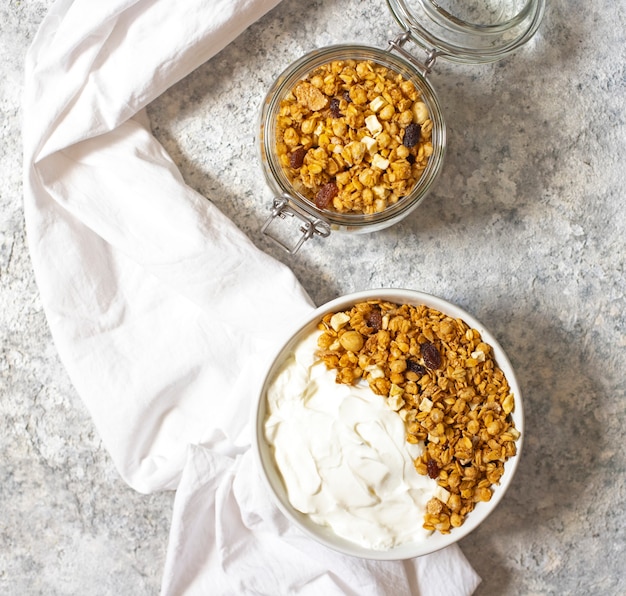 Ciotola di muesli casalingo con yogurt greco su uno sfondo chiaro. vista dall'alto