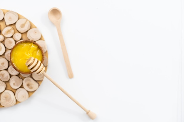 Foto ciotola di miele su sfondo bianco. simbolo di vita sana e medicina naturale. aromatico e gustoso. vista dall'alto