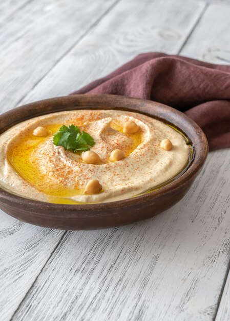 Bowl of hummus garnished with olive oil and paprika