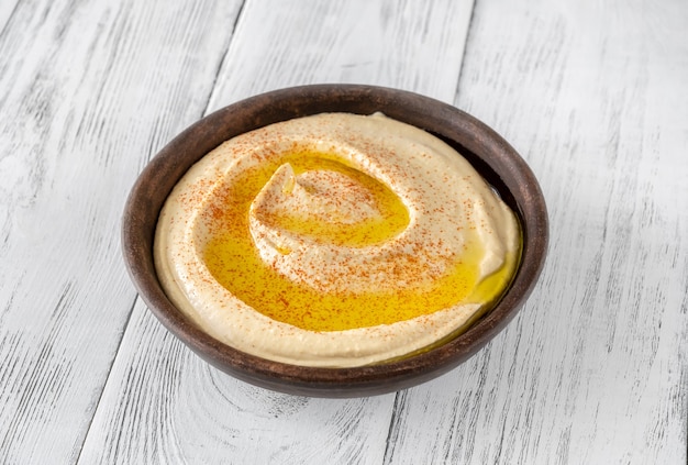 Bowl of hummus garnished with olive oil and paprika