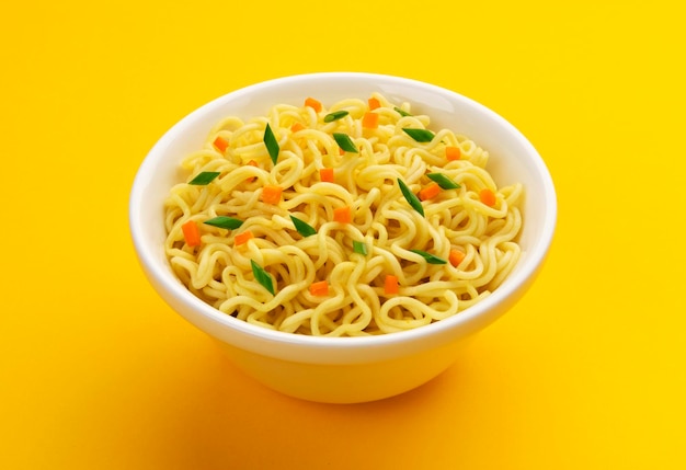 Bowl of instant noodles isolated on yellow background with copy space