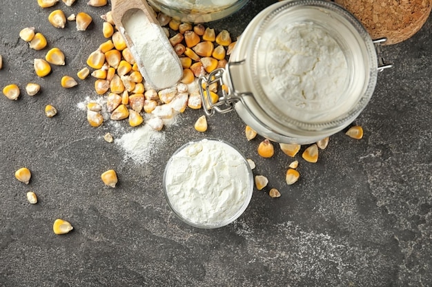 Bowl and jar with corn starch and kernels on table