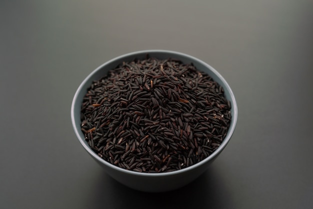 Bowl of jasmine black rice on black backgrounds