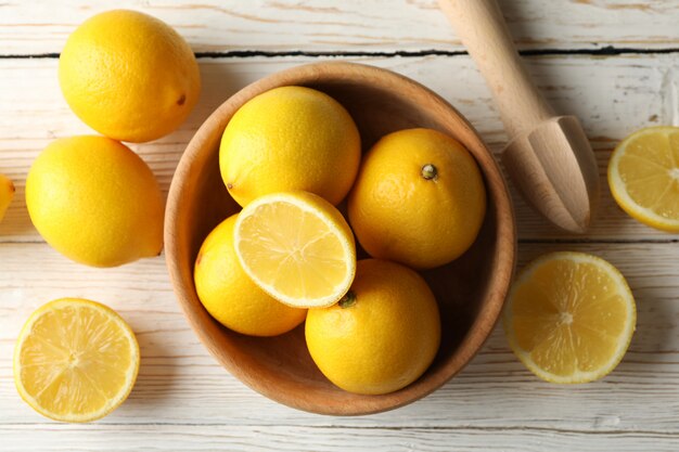 나무 표면에 그릇, 레몬, 나무 과즙 기