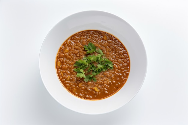 A bowl of lentil soup with parsley on top