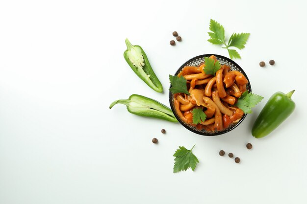 Bowl of marinated mushrooms on white background