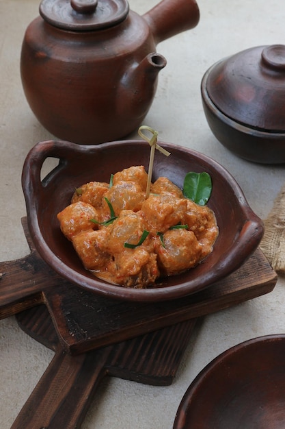 A bowl of meatballs with a leaf on it