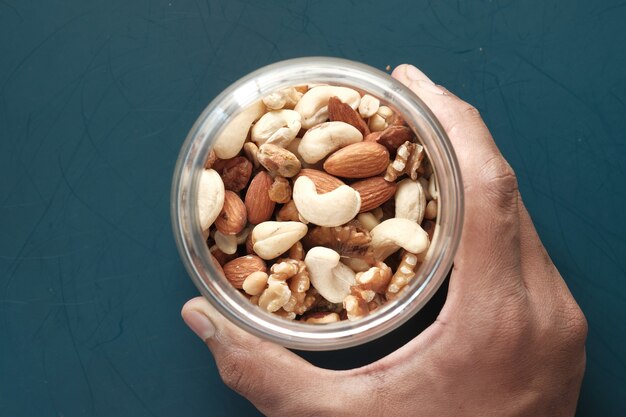 Bowl of mixed nut on green background