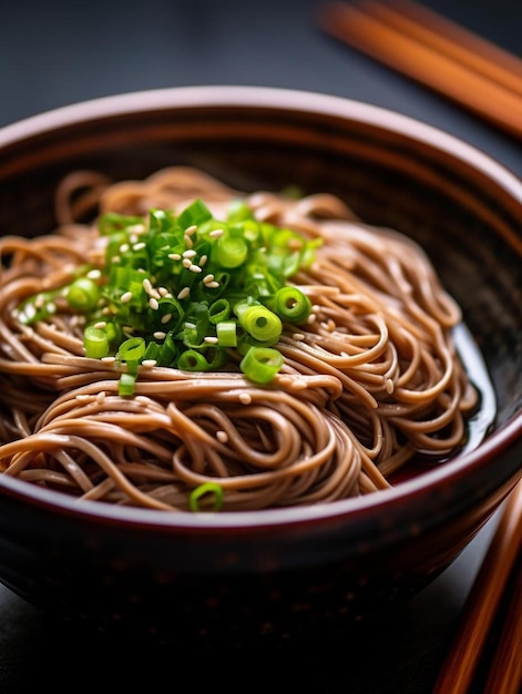 a bowl of noodles with green onions and chopsticks