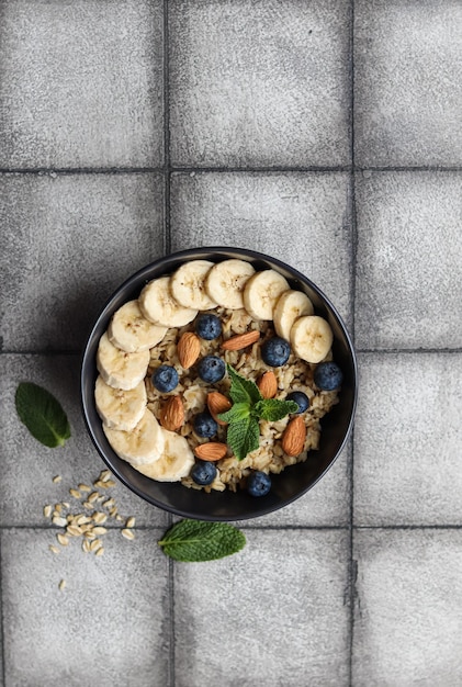 A bowl of oatmeal with blueberries almonds and banana