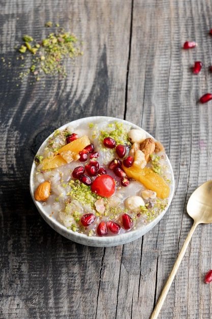 A bowl of oatmeal with nuts and seeds on a wooden table.