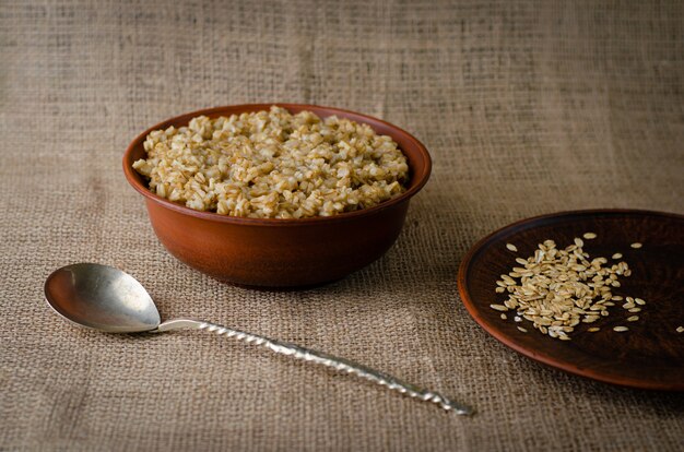 A bowl of oats porridge on sackcloth