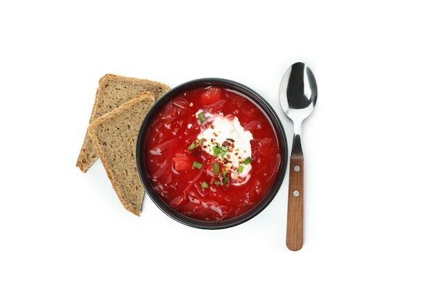 Фото Чаша свекольного супа, ложка и хлеб, изолированные на белом