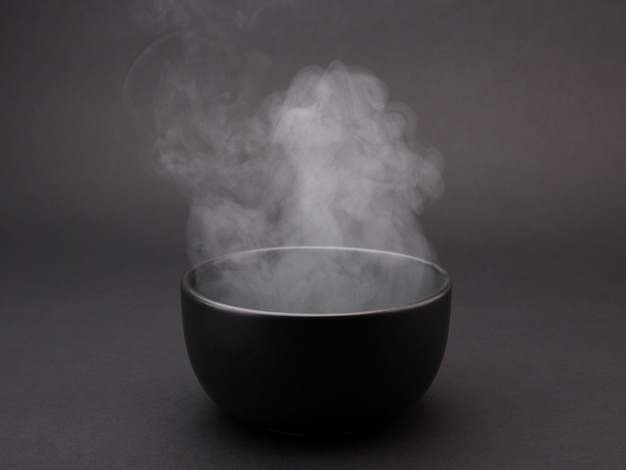 Фото Чаша горячего супа на черном