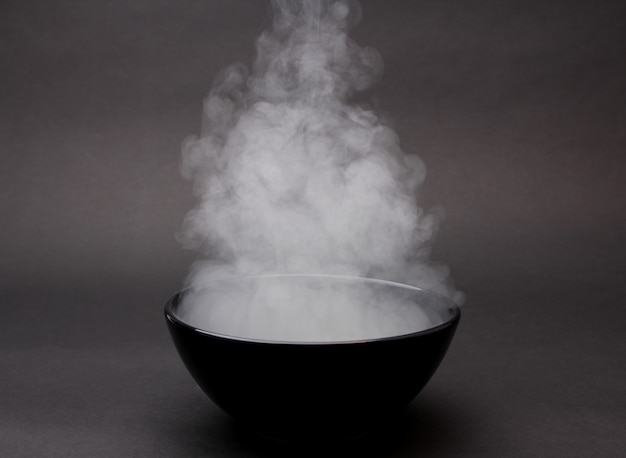 Фото Чаша горячего супа на черном
