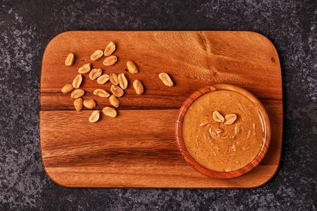 Фото Чаша арахисового масла на деревянной доске