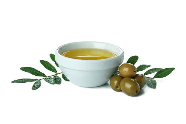 Bowl of olive oil, twigs and olives isolated on white background