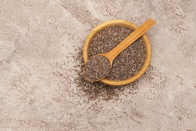 Bowl of organic natural chia seeds closeup on concrete background or table