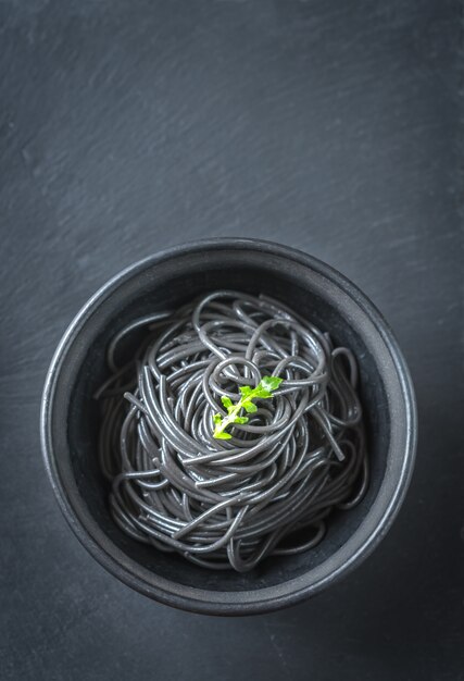 Bowl of pasta with squid ink with arugula leaf