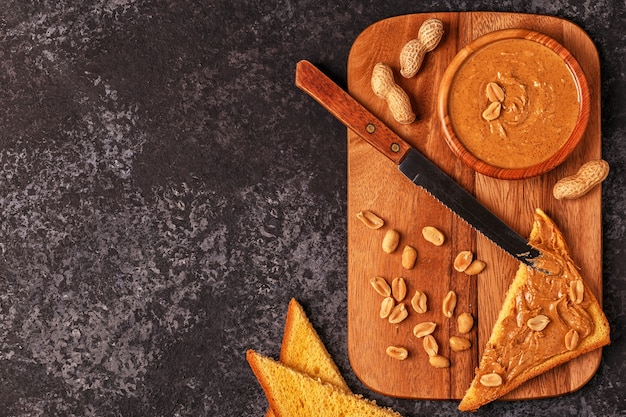 Bowl of peanut butter on wooden breakfast board