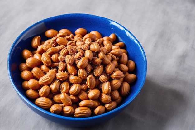 A bowl of peanuts is shown on a gray table.