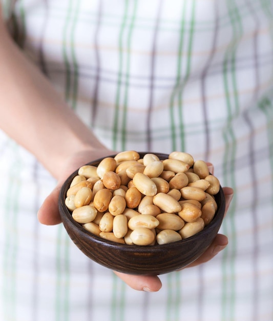 A bowl peanuts in woman hands