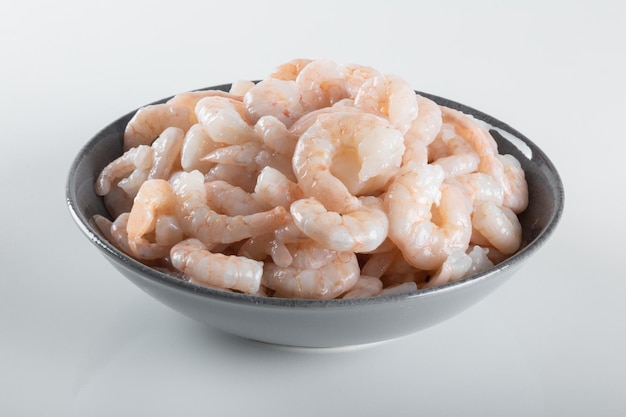 A bowl of peeled fresh raw white shrimp with tail