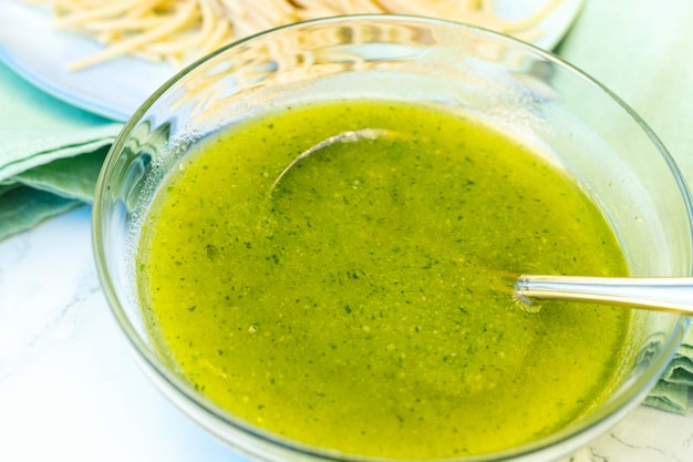 Bowl of pesto sauce with spoon and spaghetti