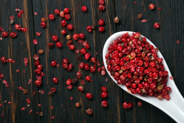 a bowl of pomegranate seeds on a wooden table.