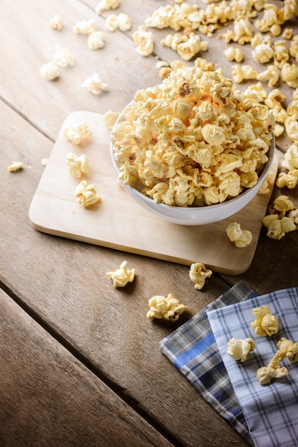 Bowl of popcorn on the wooden table, selective focus